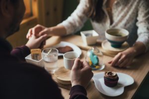 カフェで手を握り合うカップル