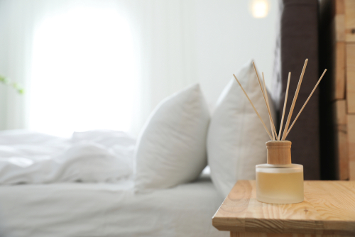 Reed,Diffuser,On,Nightstand,Near,Bed,In,Room.,Modern,Interior