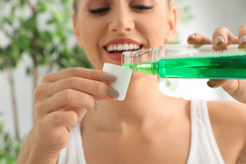 Woman,Pouring,Mouthwash,From,Bottle,Into,Cap,,Closeup.,Teeth,Care