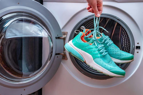 Washing,,Cleaning,Dirty,Sports,Shoes,In,A,Washing,Machine,At
