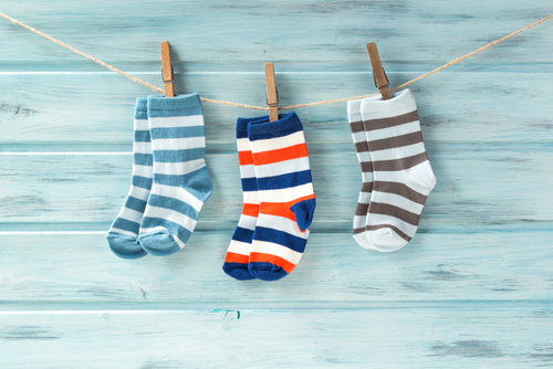 Baby,Striped,Socks,On,A,Clothesline,On,Wooden,Background