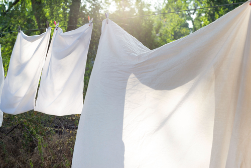 White,Bedding,,Clothesline,Drying,,Hanging,Outside.,Against,The,Background,Of
