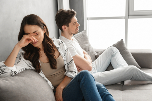 Photo,Of,Disappointed,Couple,Sitting,Together,On,Sofa,At,Home