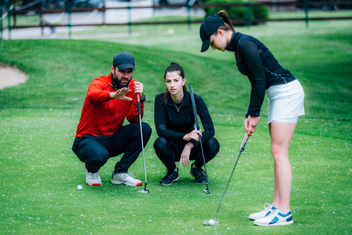 Golf,Putting,Lesson,,Two,Young,Female,Golfers,Practicing,Putting,With