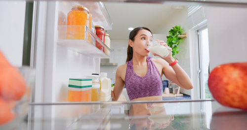 Asian,Woman,Takes,Milk,And,Drinks,It,From,Opened,Refrigerator