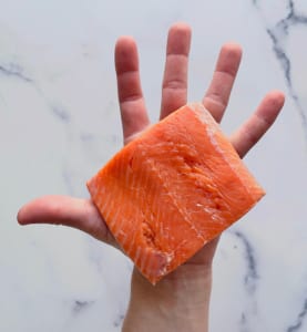 Salmon,In,The,Palm,Of,A,Hand,Over,A,Marble