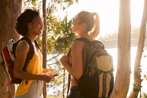 Two,Female,Friends,With,Map,And,Backpacks,On,Vacation,Hiking