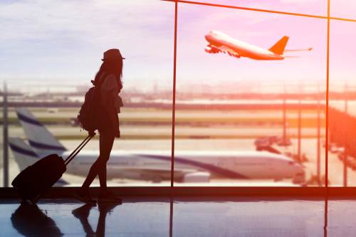 Young,Woman,Is,Standing,Near,Window,At,The,Airport,And