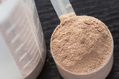Scoop,Of,Chocolate,Whey,Isolate,Protein,Next,To,The,Translucent