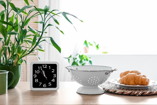 Clock,,Colander,And,Plate,With,Croissants,On,Counter,In,Kitchen