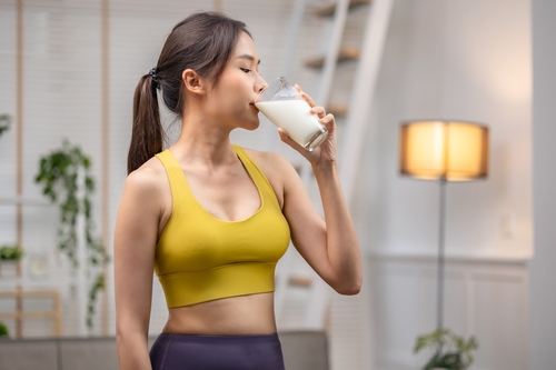 Attractive,Fitness,Asian,Woman,Finishing,Workout,And,Drinking,Protein,Milk